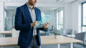 Un homme d'affaires en veste bleue manipule une interface numérique transparente affichant des graphiques de données.